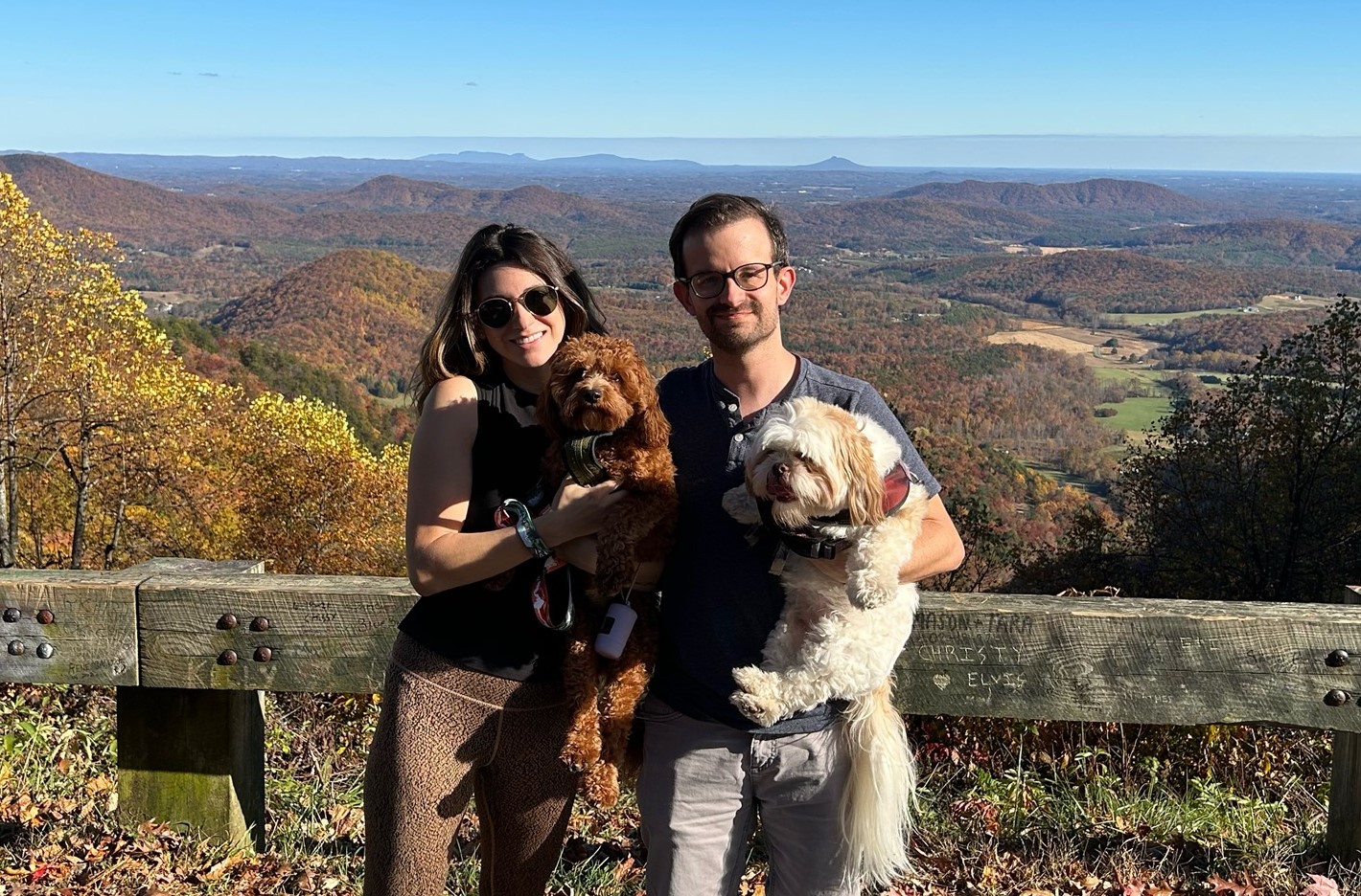 Couple with dogs posing before a fall forest