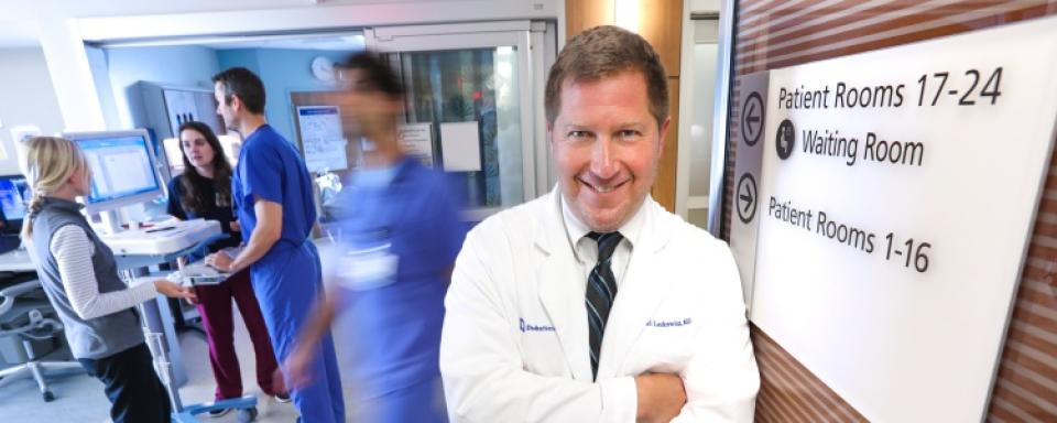 man at busy hospital smiling at camera